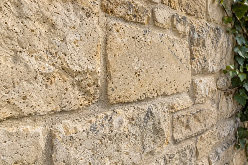 Close view of pale limestone masonry with natural texture and sound mortar